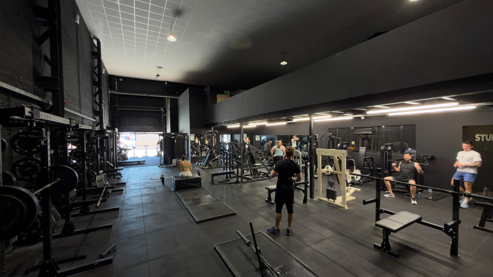 Fortitude Fitness gym floor with racks, benches and members training